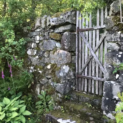 an old stone wall with a wooden gate at Mews Cottage Ardoch Lodge Strathyre in Strathyre