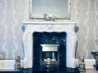 a fireplace in a living room with a mirror at THE LION'S DEN ON ROYAL STREET in Gourock
