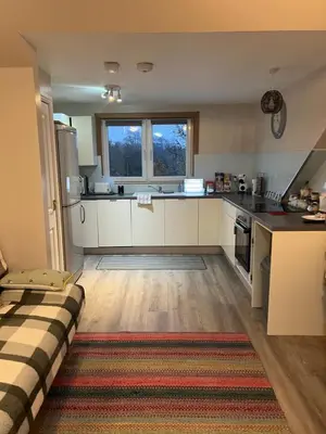 a kitchen with white cabinets and a large window at “A Wee Pad in Dunfermline” in Dunfermline