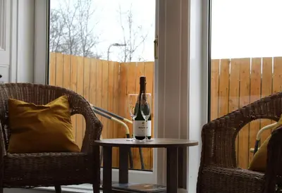 a bottle of wine on a table next to two chairs at The Woodhouse Hotel in Largs
