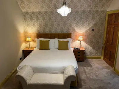 a bedroom with a large bed with two night stands and two lamps at The Farmhouse B&B in Dunkeld