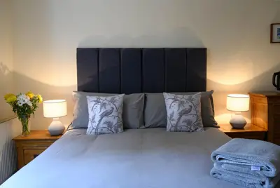 a bedroom with a large bed with two lamps at The Farmhouse B&B in Dunkeld