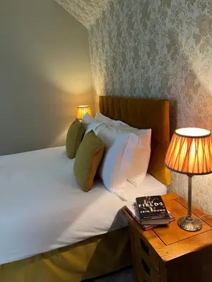a bedroom with a bed and a table with a lamp at The Farmhouse B&B in Dunkeld