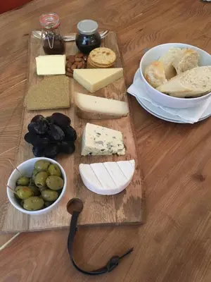 a table with a bunch of cheese and other foods at The Farmhouse B&B in Dunkeld