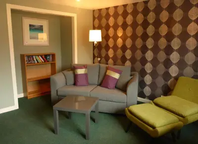 a living room with a couch and a table at Arivonie Lochside Cottage in Glencoe