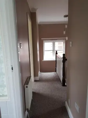 an empty hallway with a window and a stairway at Home2Home Meadow Close in East Kilbride