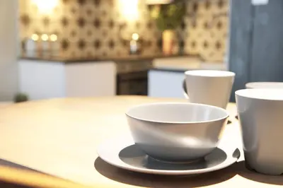 a table with two cups and a plate on it at Boutique Bothy - Unique Bolthole in the New Town in Edinburgh
