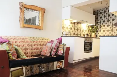 a living room with a couch and a kitchen at Boutique Bothy - Unique Bolthole in the New Town in Edinburgh