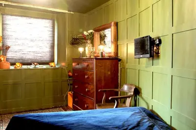 a bedroom with a bed and a dresser and a window at Boutique Bothy - Unique Bolthole in the New Town in Edinburgh