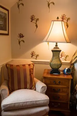 a living room with a chair and a lamp on a dresser at Kilmeny in Ballygrant