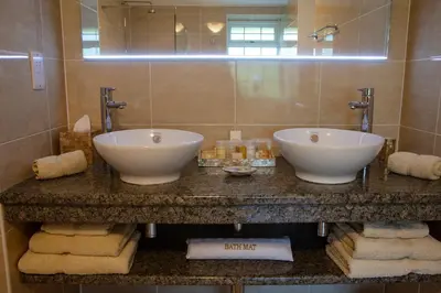 a bathroom with two sinks and a mirror and towels at Kilmeny in Ballygrant
