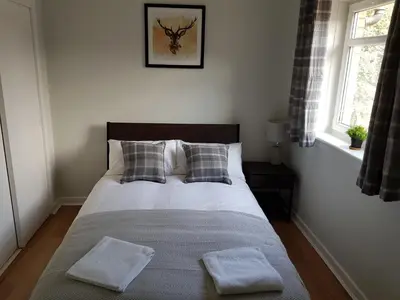 a bedroom with a bed with two pillows and a window at The Abercromby Townhouse - Close to Merchant City in Glasgow