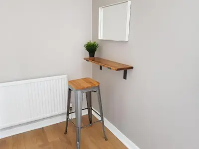 a stool next to a wall with a mirror at The Abercromby Townhouse - Close to Merchant City in Glasgow