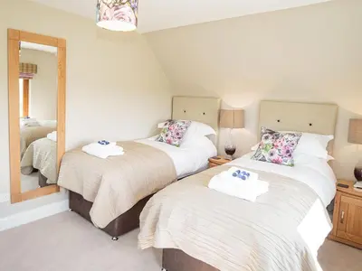 two beds in a room with a mirror at Corsewall Castle Farm Lodges in Stranraer