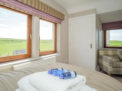 a room with a bed with towels on a table at Corsewall Castle Farm Lodges in Stranraer