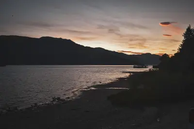 a sunset on the shore of a body of water at Lodge at Loch Lomond in Glasgow