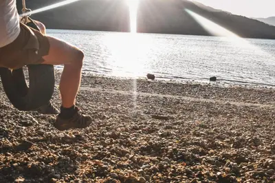 a person standing on a beach near a body of water at Lodge at Loch Lomond in Glasgow