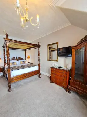 a bedroom with a bed and a mirror and a dresser at Corriemar House in Oban