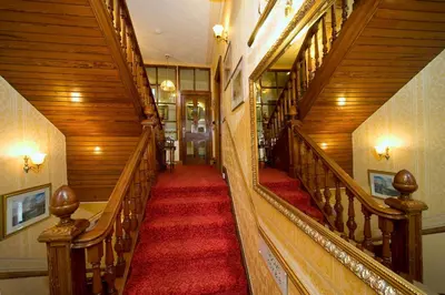 a staircase in a building with a red carpet at Corriemar House in Oban