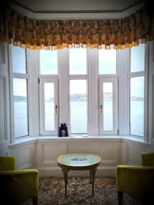 a room with a table in front of windows at Corriemar House in Oban