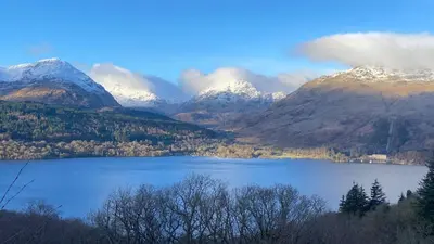 a view of a lake with snow covered mountains at Inversnaid Bunkhouse in Inversnaid
