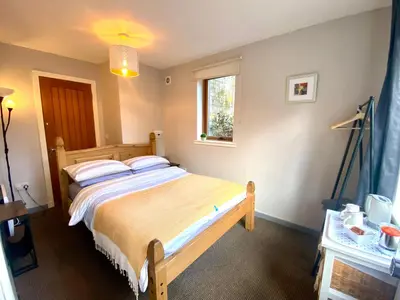 a bedroom with a large bed and a window at Inversnaid Bunkhouse in Inversnaid