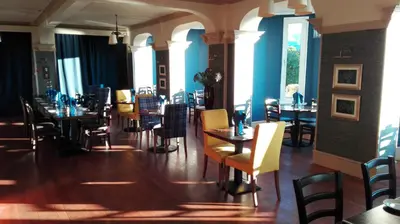 a dining room with tables and chairs and windows at The Lodge on the Loch by OYO in Onich