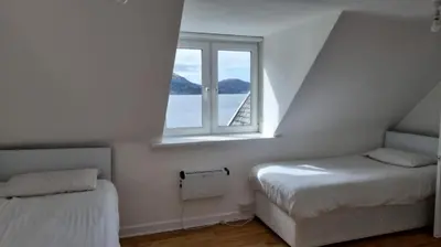 a small bedroom with a bed and a window at The Lodge on the Loch by OYO in Onich