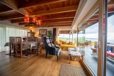 a dining room and living room with a table and chairs at Knockderry Lodge -Private Luxury pet-friendly accommodation in Scotland with hot tub in Cove