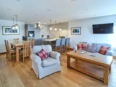 a living room and kitchen with a couch and a table at White Watch in Lochaline