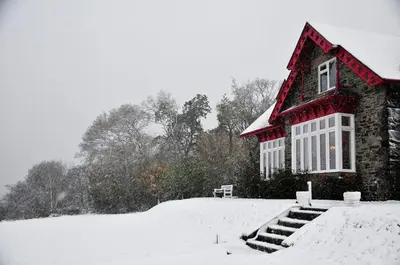 a house with a red roof in the snow at Rowardennan Youth Hostel in Rowardennan
