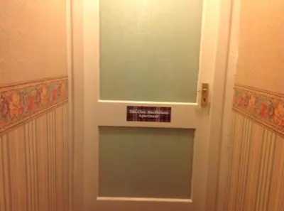 a glass door with a sign on it in a bathroom at The Clan Macfarlane Apartment in Kilmarnock