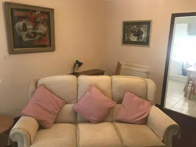 a living room with a couch with two pillows at The Clan Macfarlane Apartment in Kilmarnock