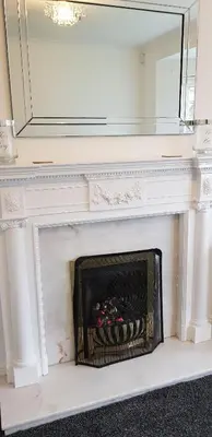 a fireplace with a mirror on top of it at Meadow House- Driveway Parking and Fireplace in East Kilbride