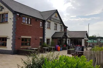 a brick building with tables and chairs in a courtyard at Meadow House- Driveway Parking and Fireplace in East Kilbride