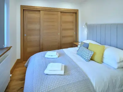 a bedroom with a bed with towels on it at Red Watch Apartment in Oban
