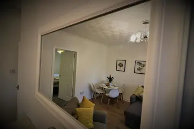 a view of a living room with a table and a mirror at Signature - Bruce Terrace Lower in High Blantyre