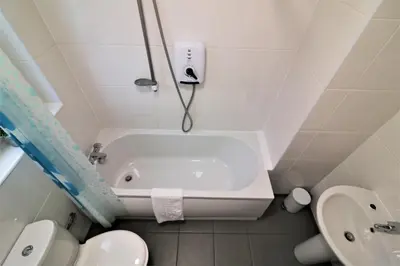 a bathroom with a tub and a toilet and a sink at Signature - Bruce Terrace Lower in High Blantyre