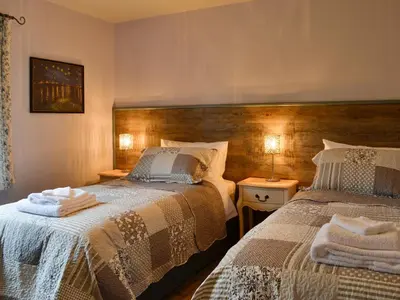 a bedroom with two beds and two night stands at Haagwood Cottage in Cretshengan