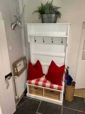 a bench with red pillows on it in a room at A Fairytale Highland Cottage in Aberfeldy