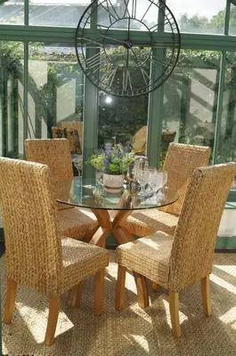 a glass table with chairs and a chandelier at A Fairytale Highland Cottage in Aberfeldy