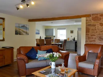 a living room with two couches and a table at The Brewers Cottage in Mauchline