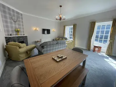 a living room with a couch and a table at Blairquhan Cottages in Maybole