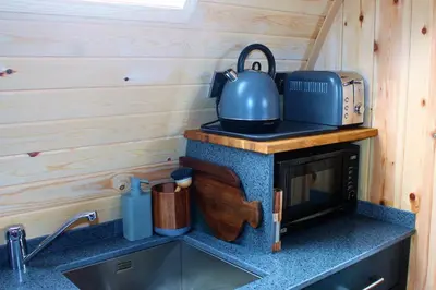 a kitchen with a tea kettle on top of a microwave at Cairnfold Cabins in Kilsyth
