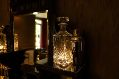 a glass bottle sitting on a shelf next to a mirror at Rhumhor House in Carrick