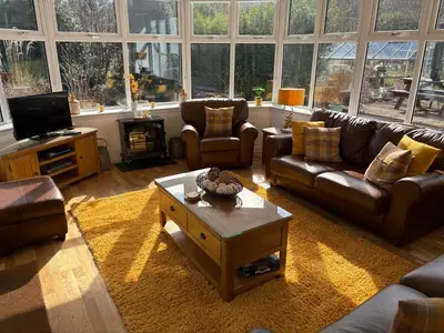 a living room with couches and a coffee table at Rhumhor House in Carrick