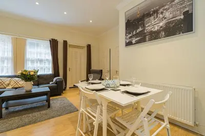 a living room with a white table and chairs at 2BR Grassmarket Apartment with Castle View in Edinburgh