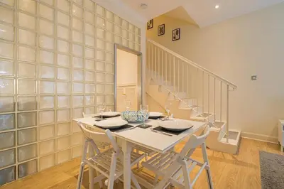 a dining room with a white table and chairs at 2BR Grassmarket Apartment with Castle View in Edinburgh