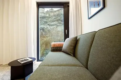 a living room with a couch and a large window at Wilde Aparthotels Edinburgh Grassmarket in Edinburgh