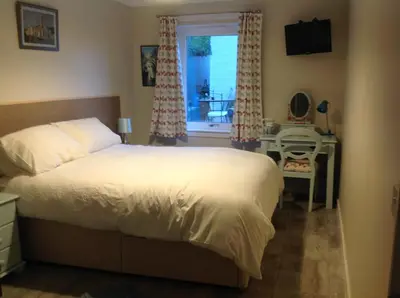 a bedroom with a bed and a window with a table at Saorsa House Culross in Fife